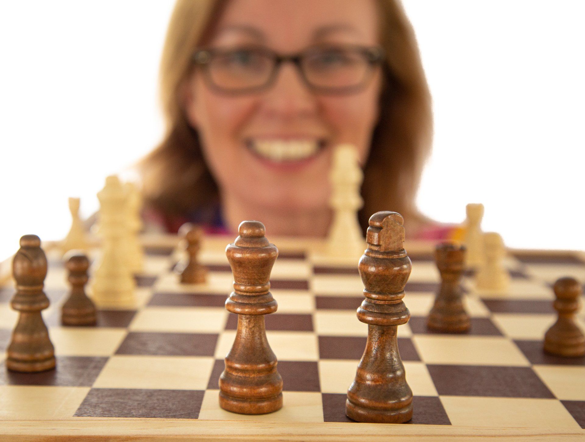 Emotipic of lady looking through chess pieces captured in Roth Read Photography studio