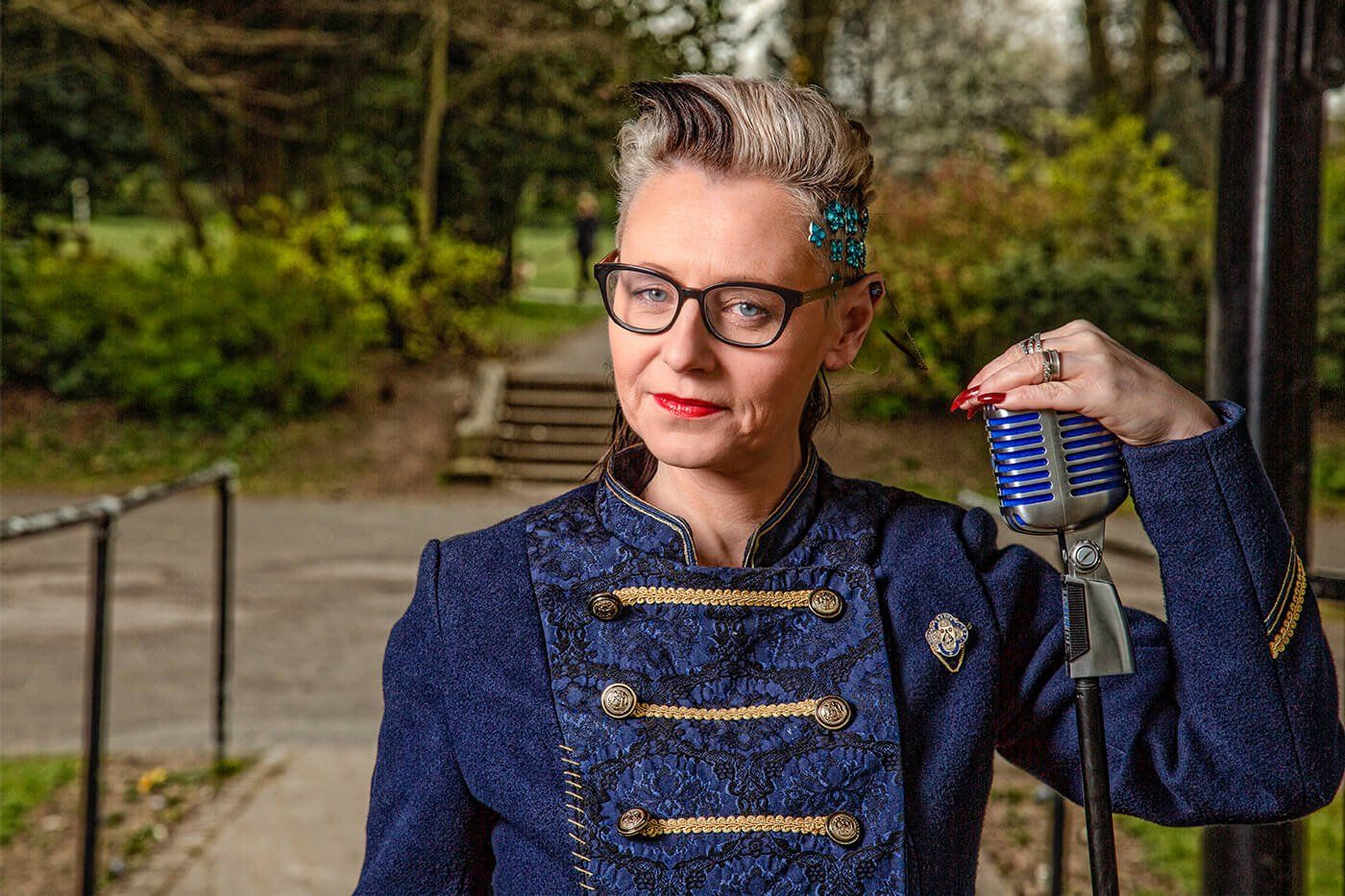 A woman in a blue jacket is holding a microphone in her hand.