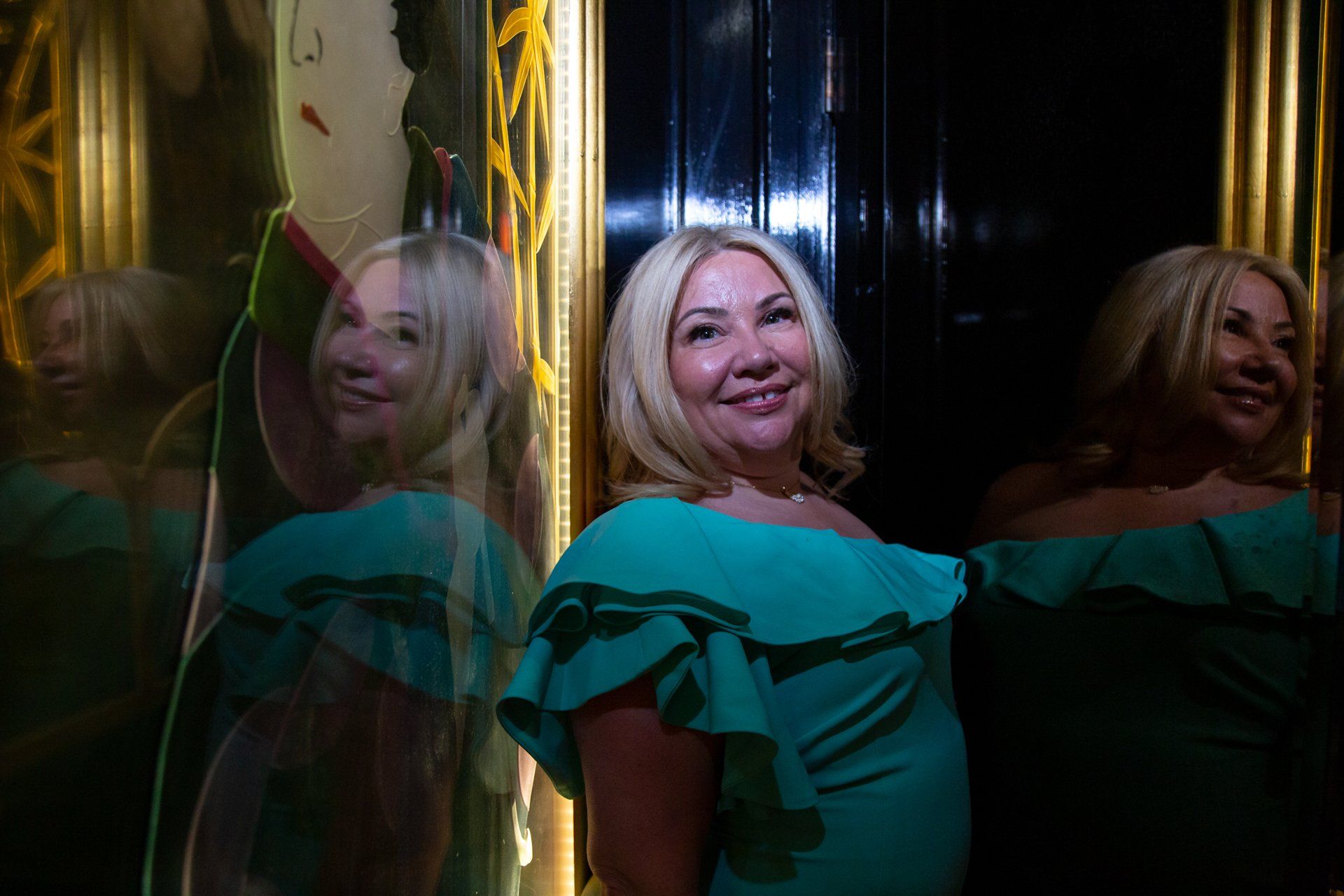Lady in blue dress reflected in mirrors at The Ivy Spinningfields, Manchester