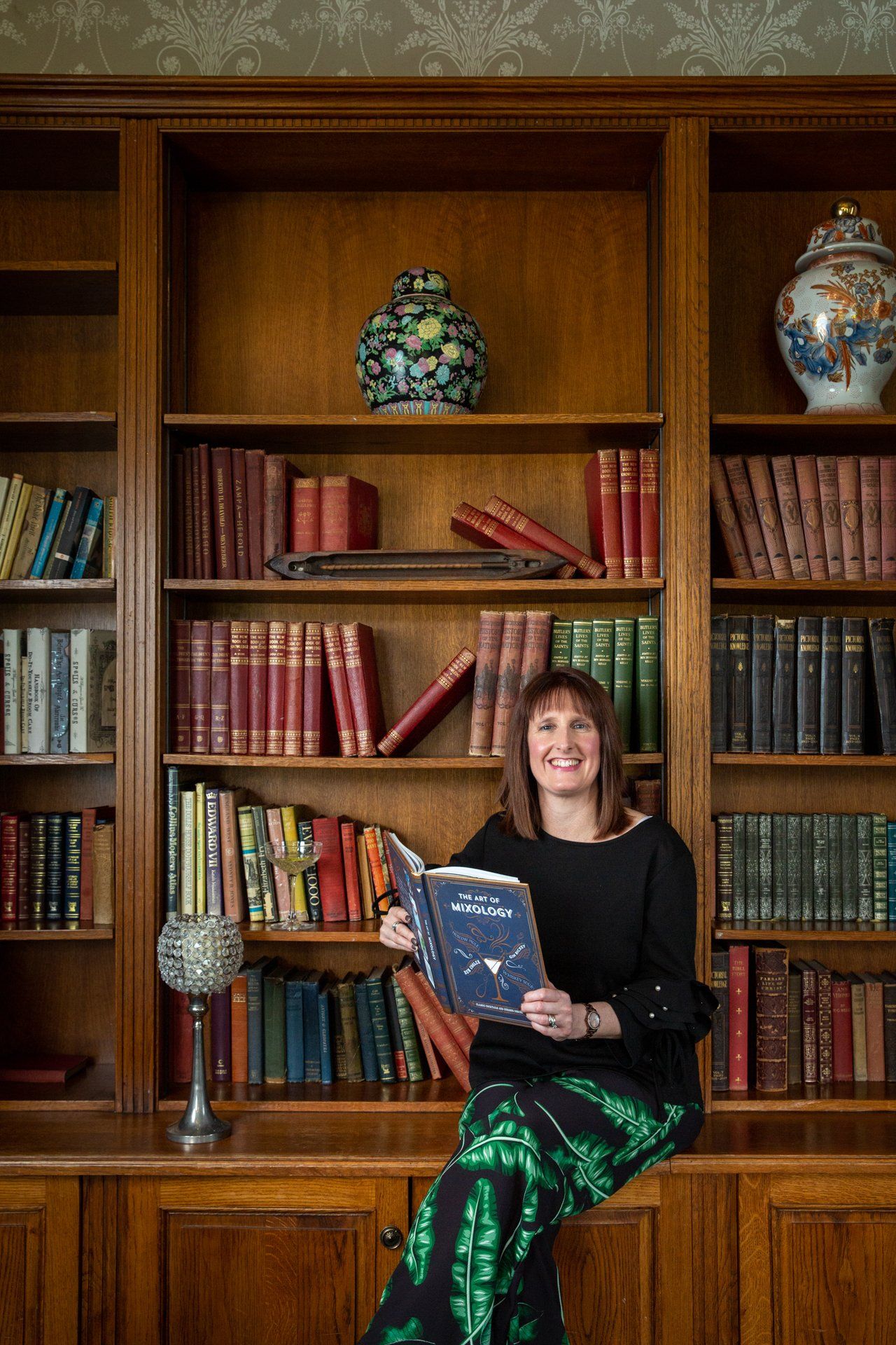 Commercial photography lady reading a cocktails book in the library at Warterton Park, Wakefield
