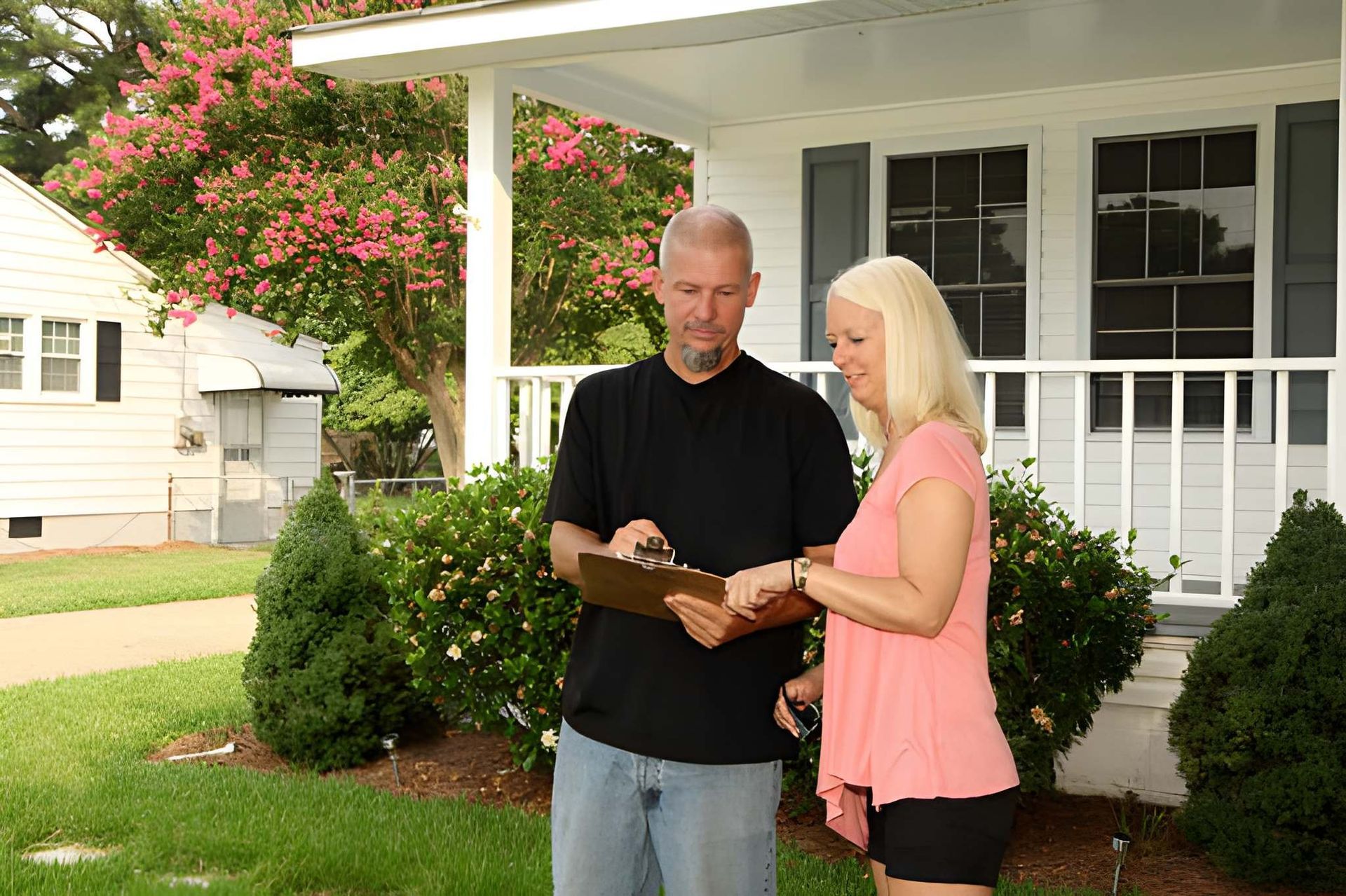 Home inspection consultation in Port St Lucie—clipboard review in front of well-kept residential property