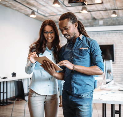 A man and a woman are looking at a tablet together.