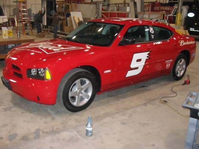 Red Dodge Charger with Budweiser logo and the number 9, indoors.