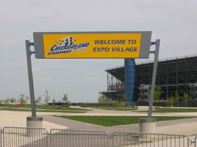 Sign at Chicagoland Speedway welcoming visitors to Expo Village. Yellow and blue colors.