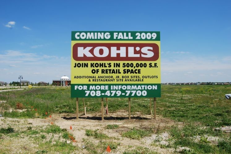 Sign advertising a Kohl's store coming Fall 2009. The sign is in a field with a phone number for more information.