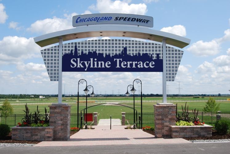 Entrance to Chicagoland Speedway's Skyline Terrace; sign with Chicago skyline silhouette, archway, and brick pillars.
