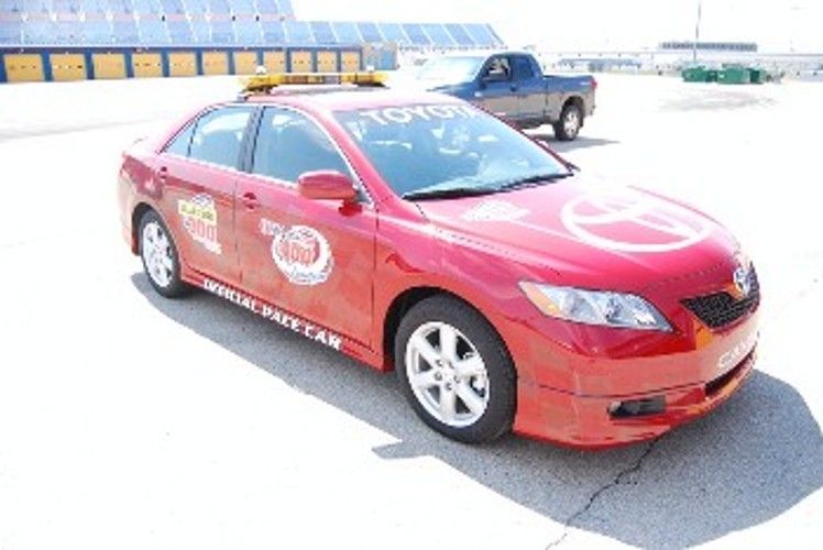 Red Toyota Camry pace car at a racetrack, marked with