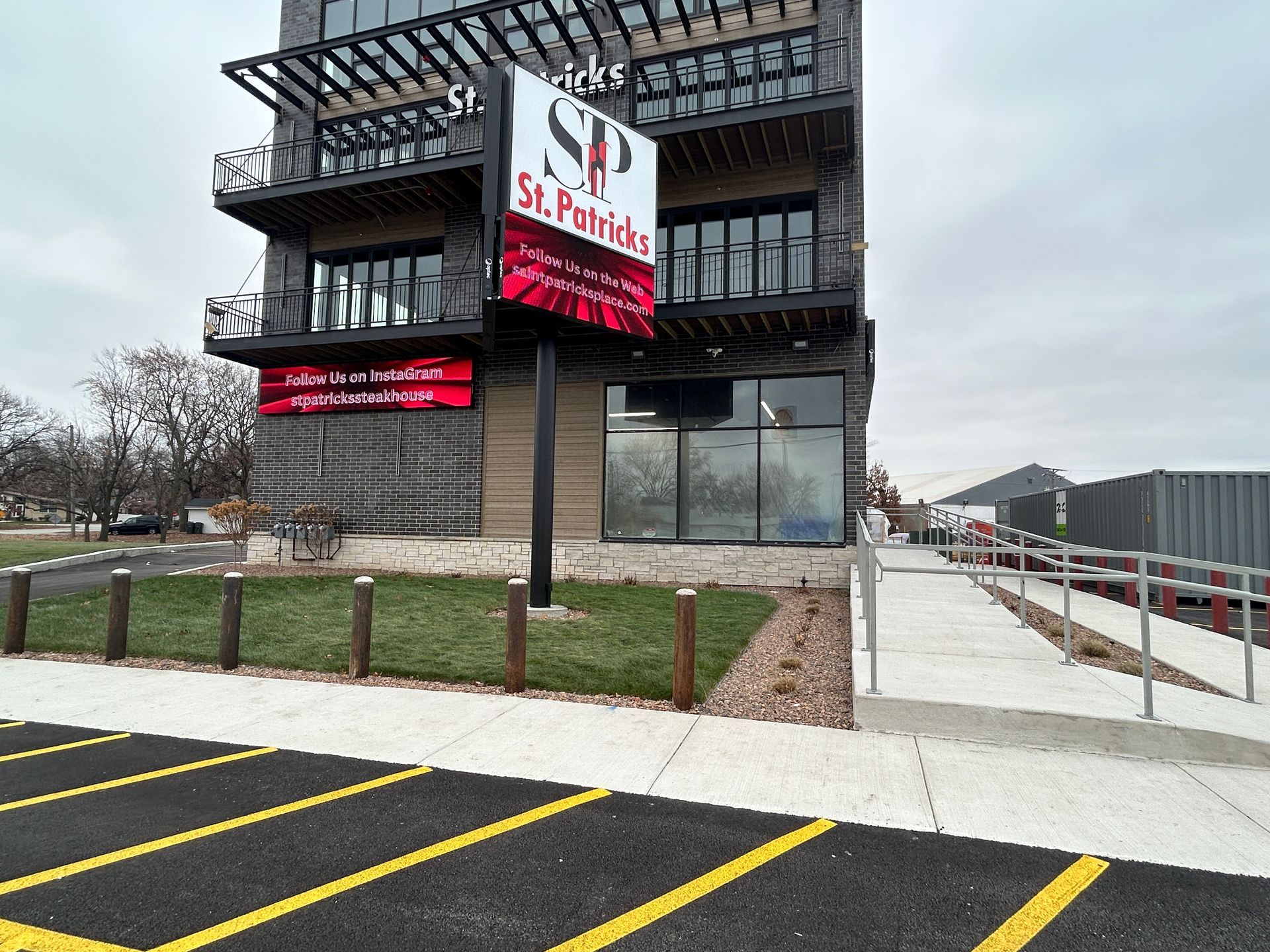 Exterior view of the St. Patrick's building with a sign and a ramp.