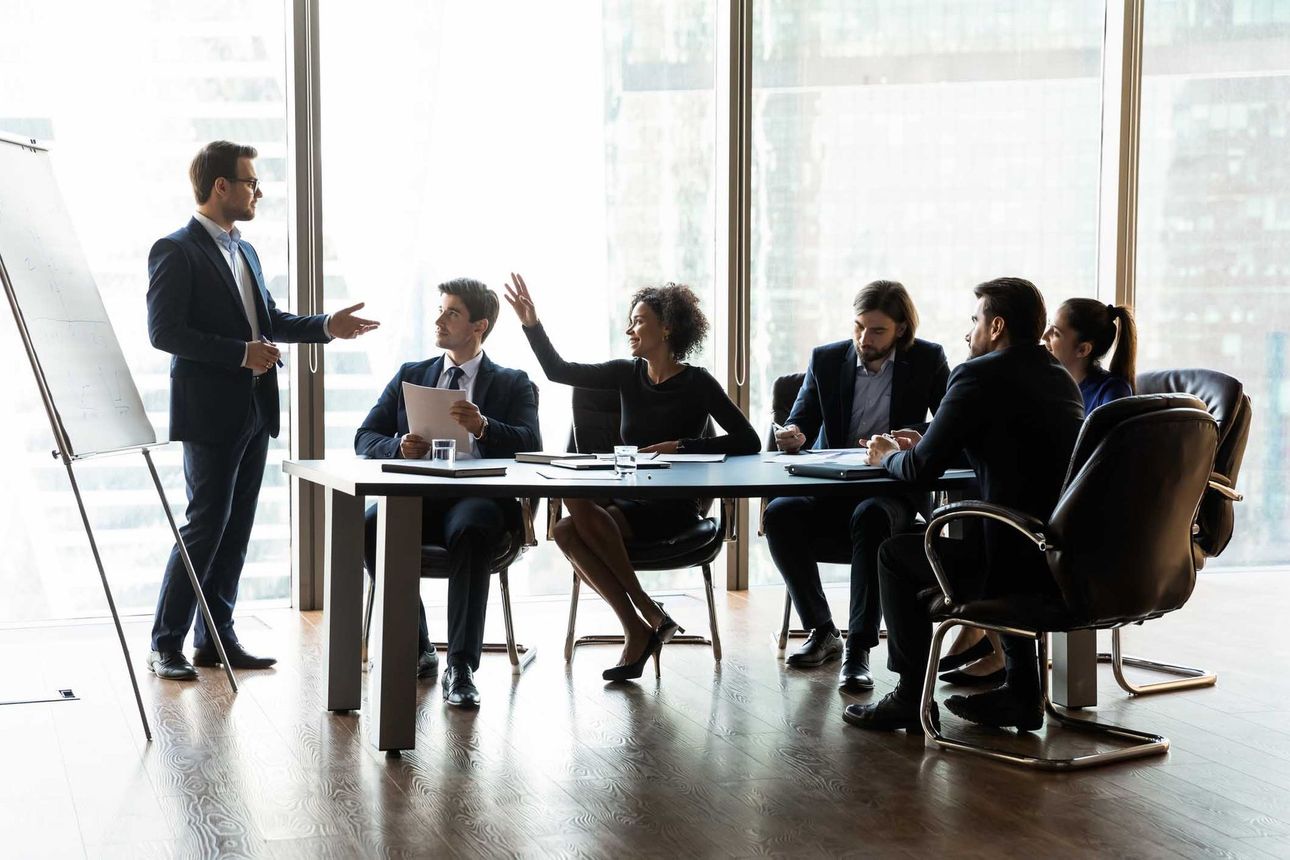 A group of business people are sitting around a table having a meeting.