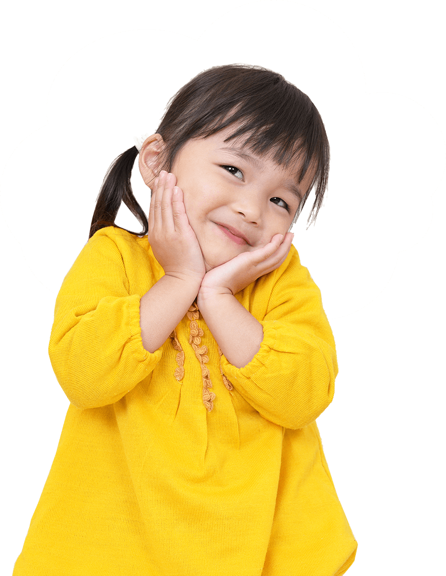 Girl in yellow sweater smiles, hands on cheeks.