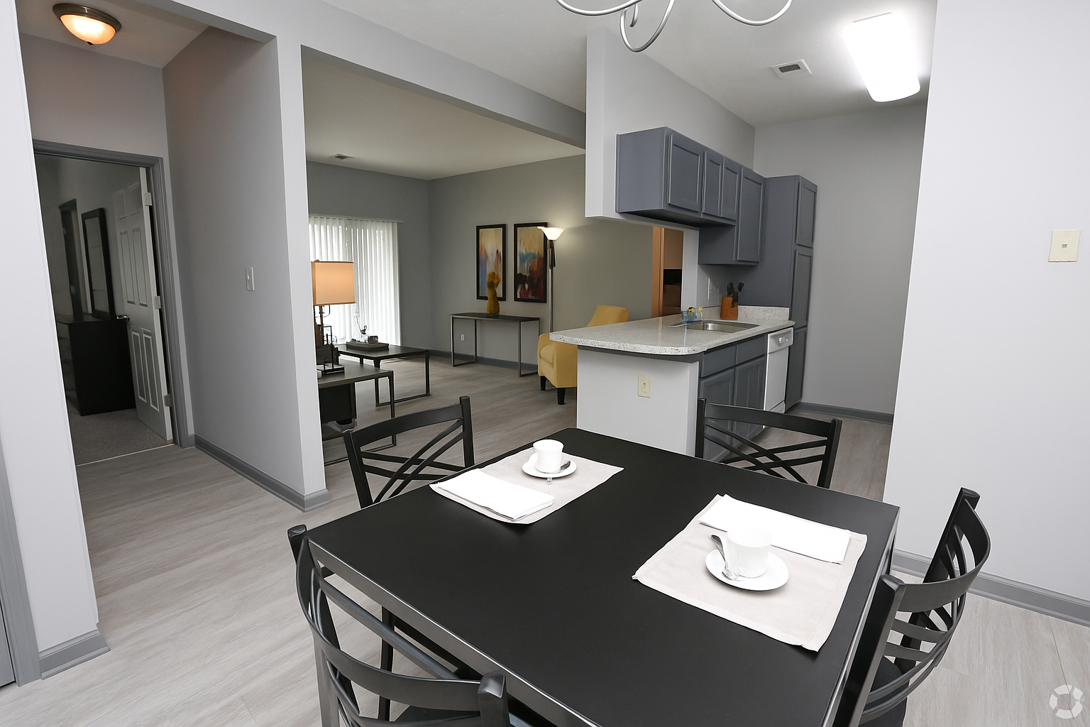 A dining room with a table and chairs and a picture on the wall.