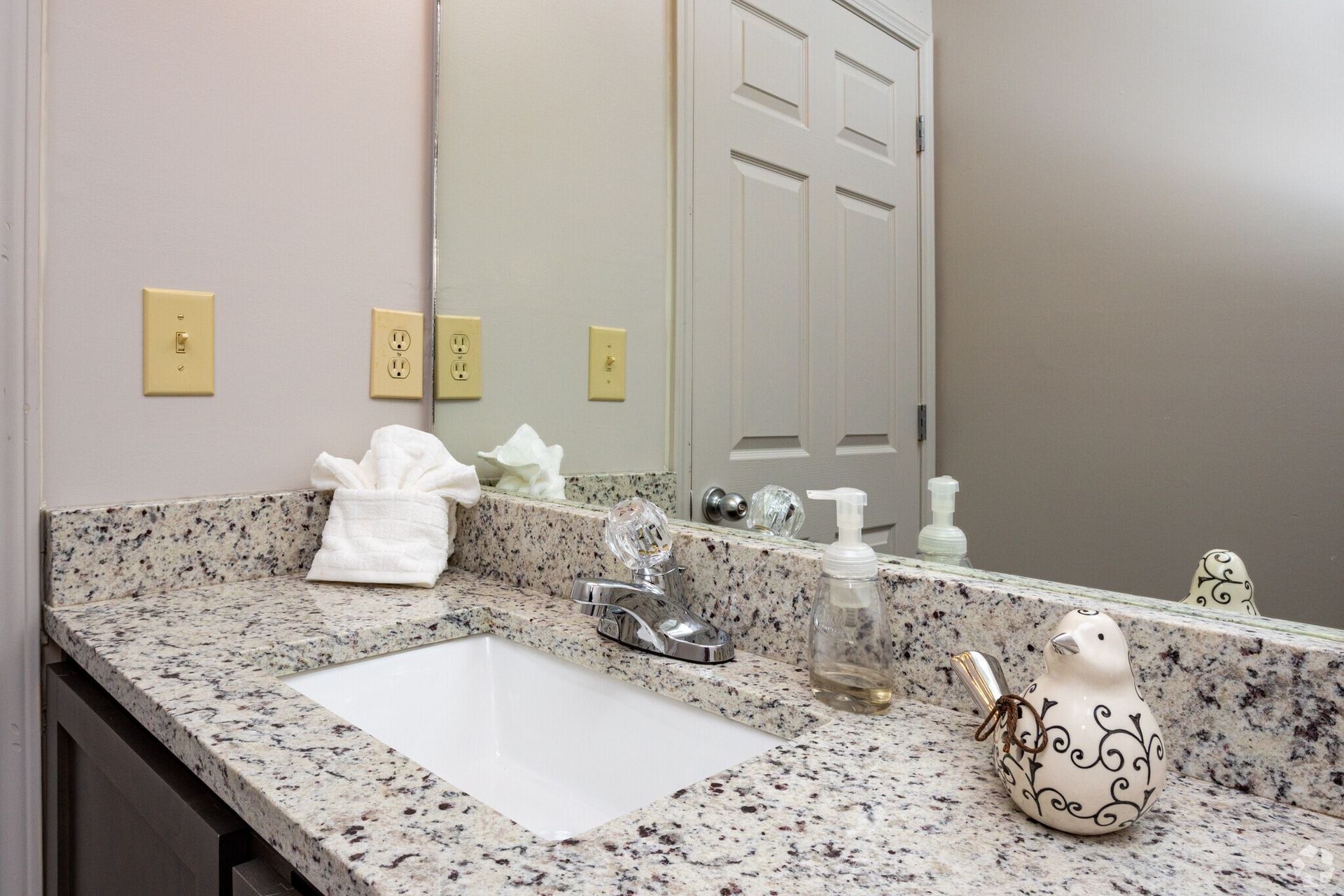 A bathroom counter with a sink and a mirror.