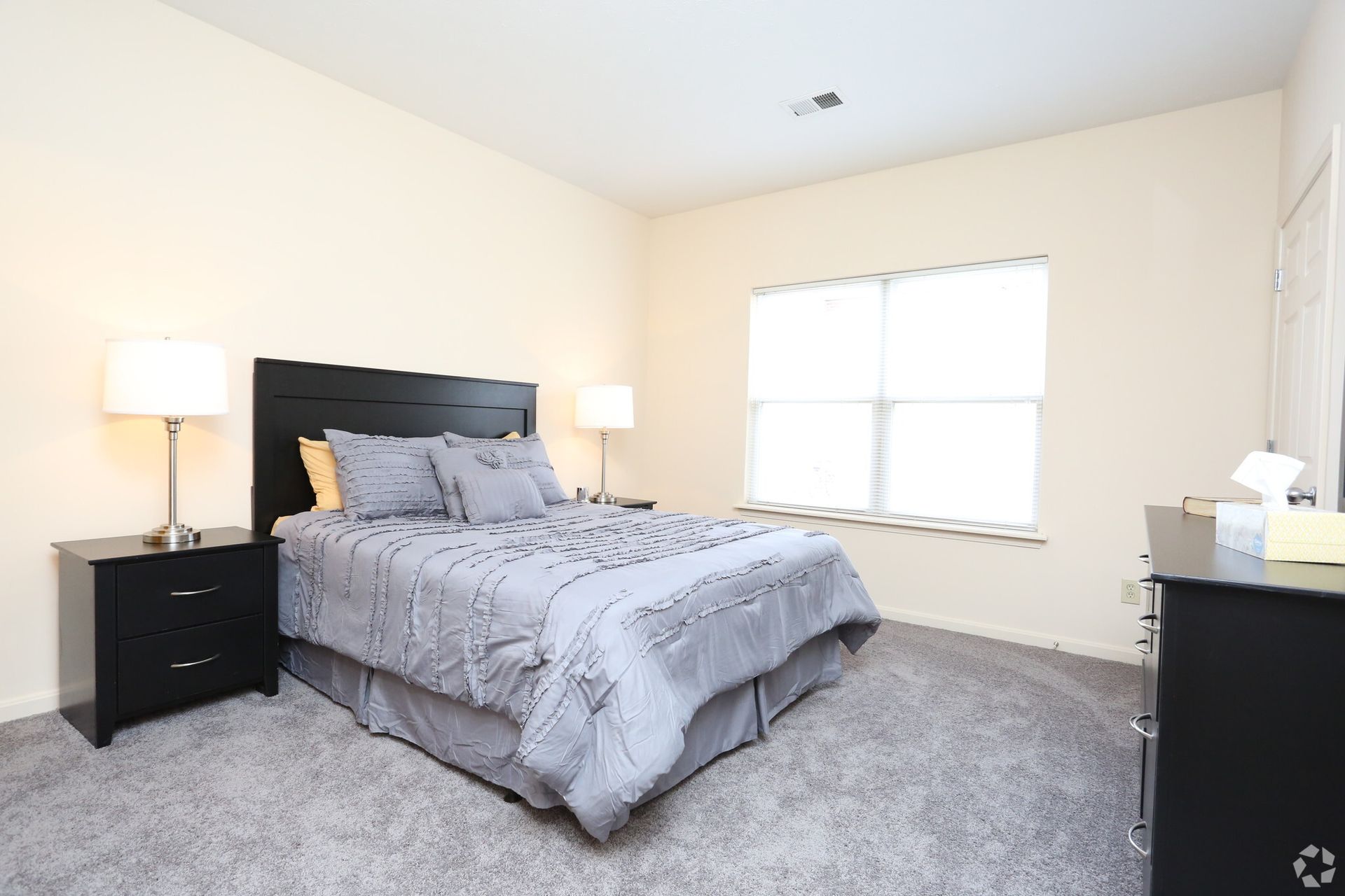 A bedroom with a bed , nightstand and dresser