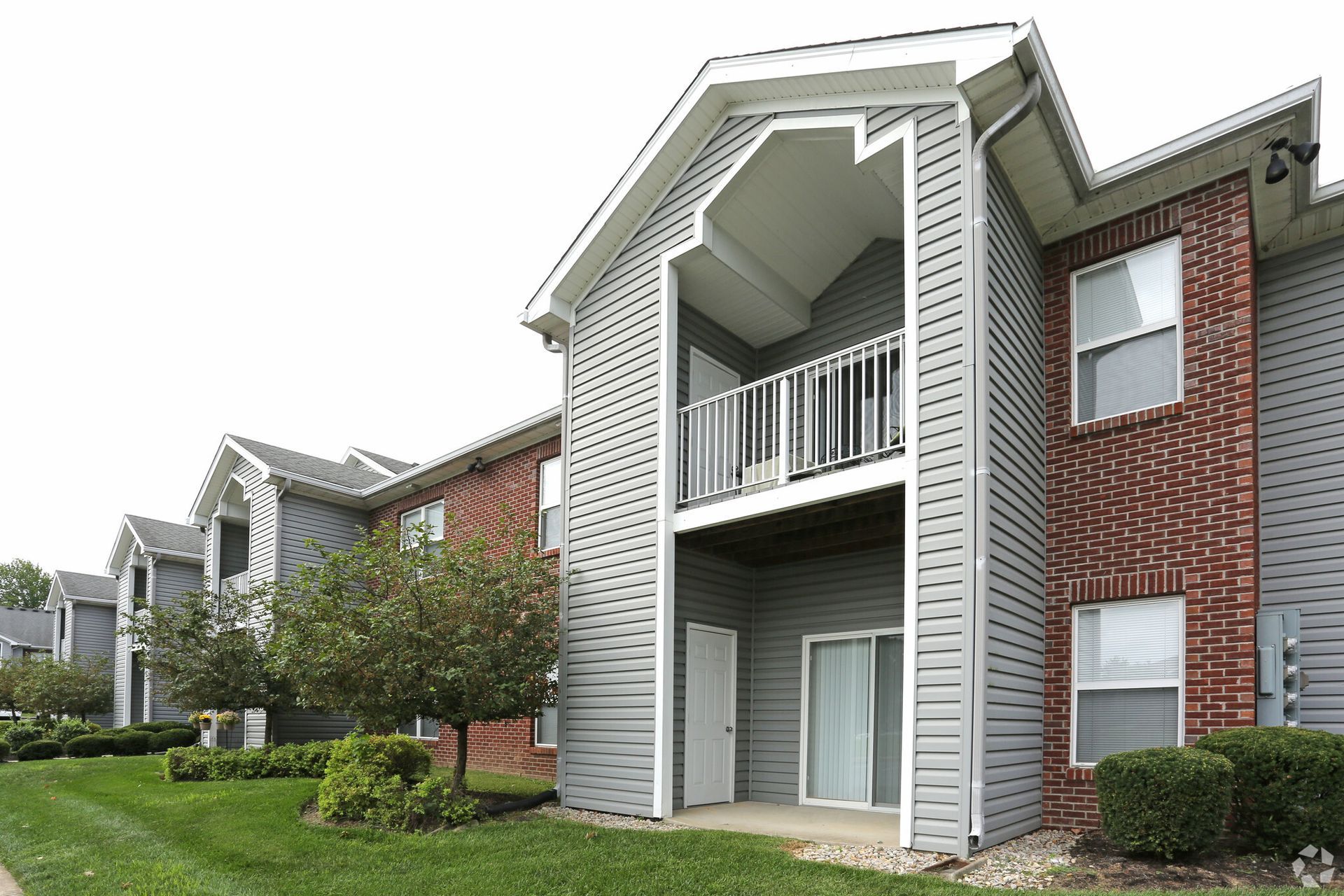 A large apartment building with a balcony and a brick wall