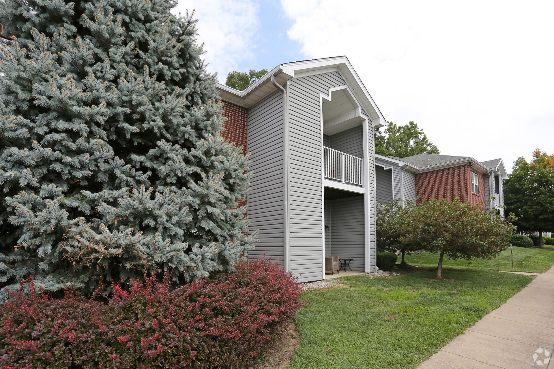 A large apartment building with a lot of trees in front of it.