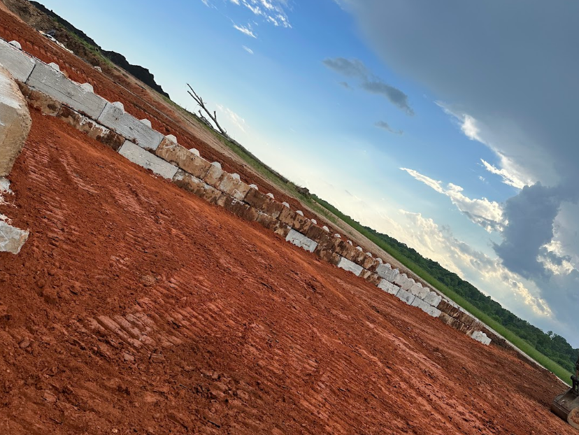 A large pile of dirt is sitting in the middle of a field.