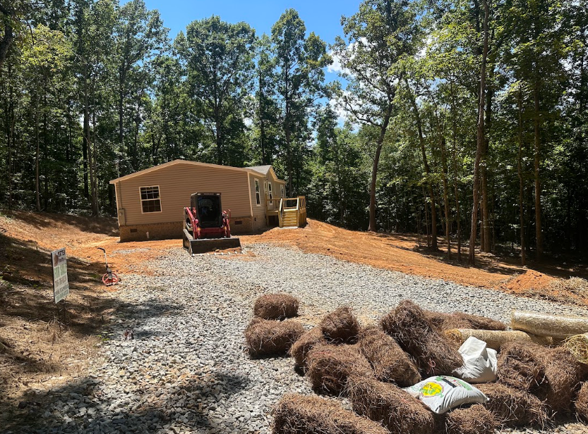 A house is being built in the woods next to a pile of hay.