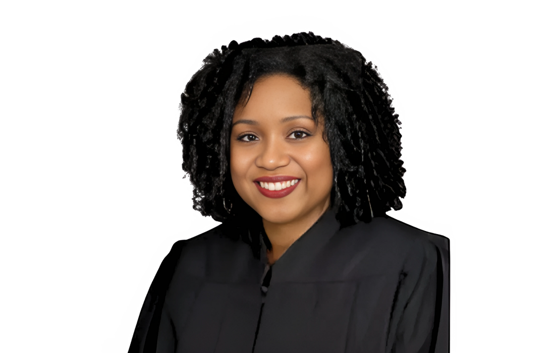 Judge in black robe smiling.