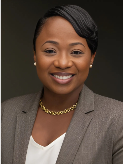 Smiling Black woman wearing a blazer and gold necklace; professional headshot.