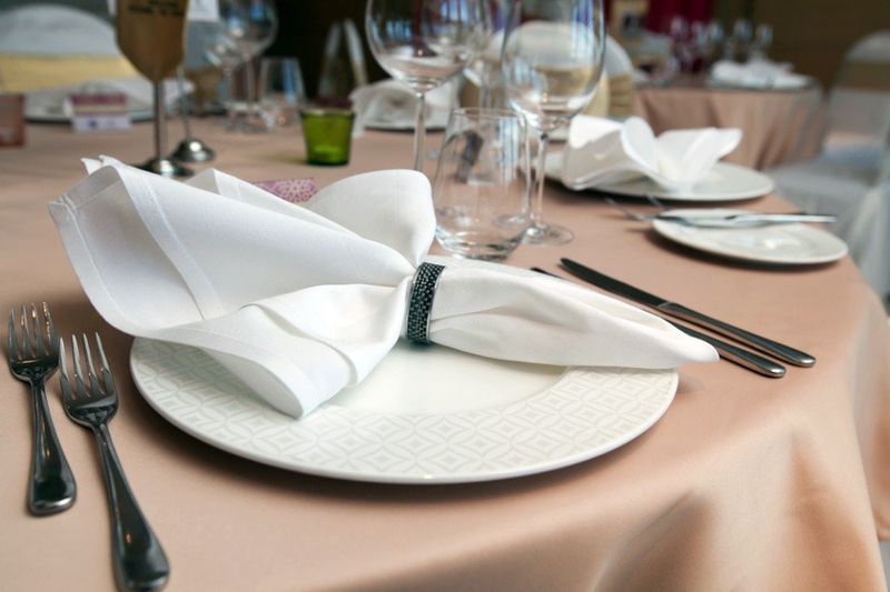 table set with beige tablecloth and white napkins