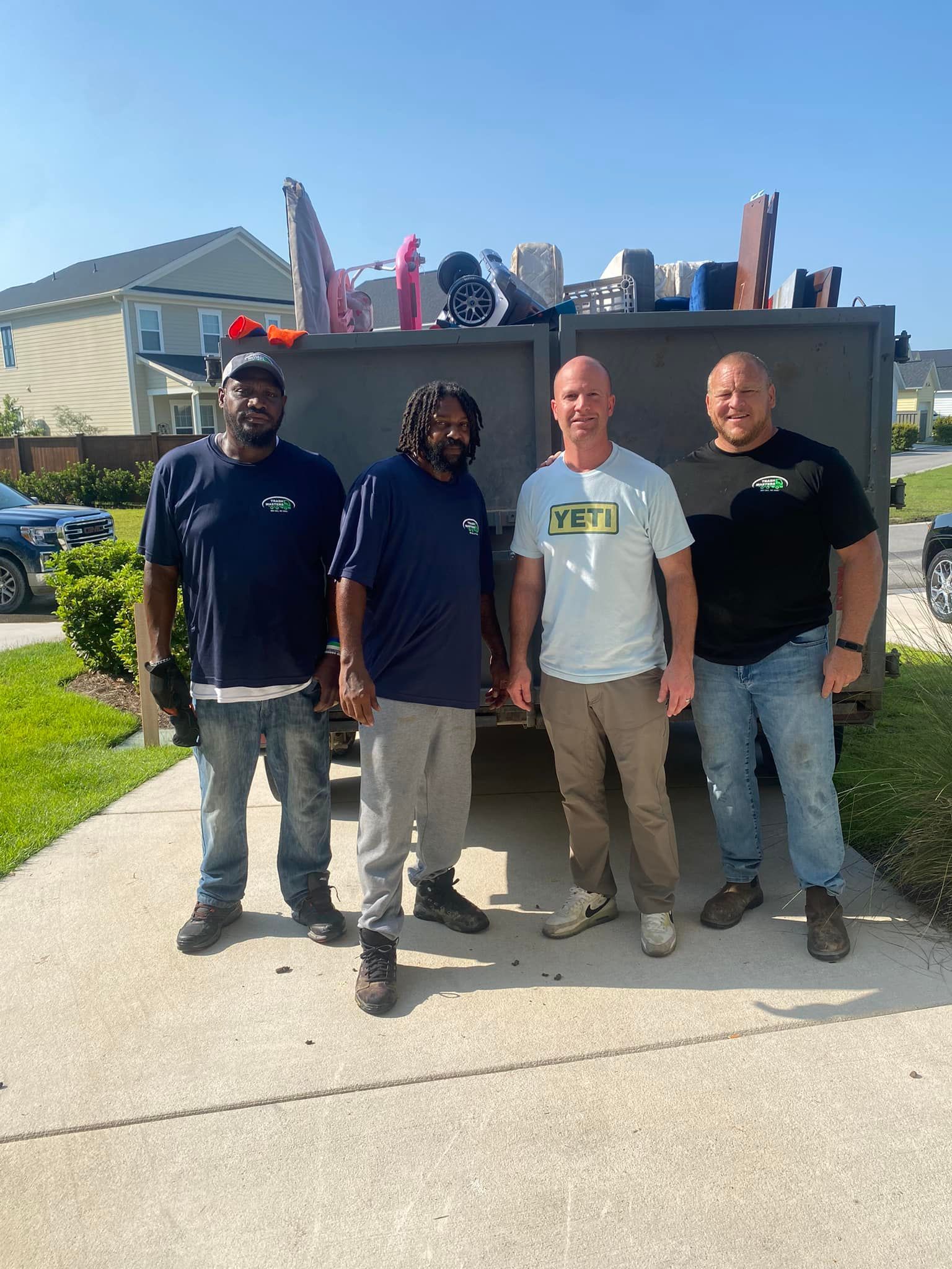 A group of men are standing in front of a dumpster. | Summerville, SC | Trash Masters