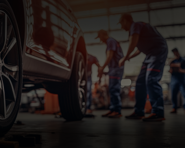 Up close of car in garage, technicians at work | Innovative Auto Service