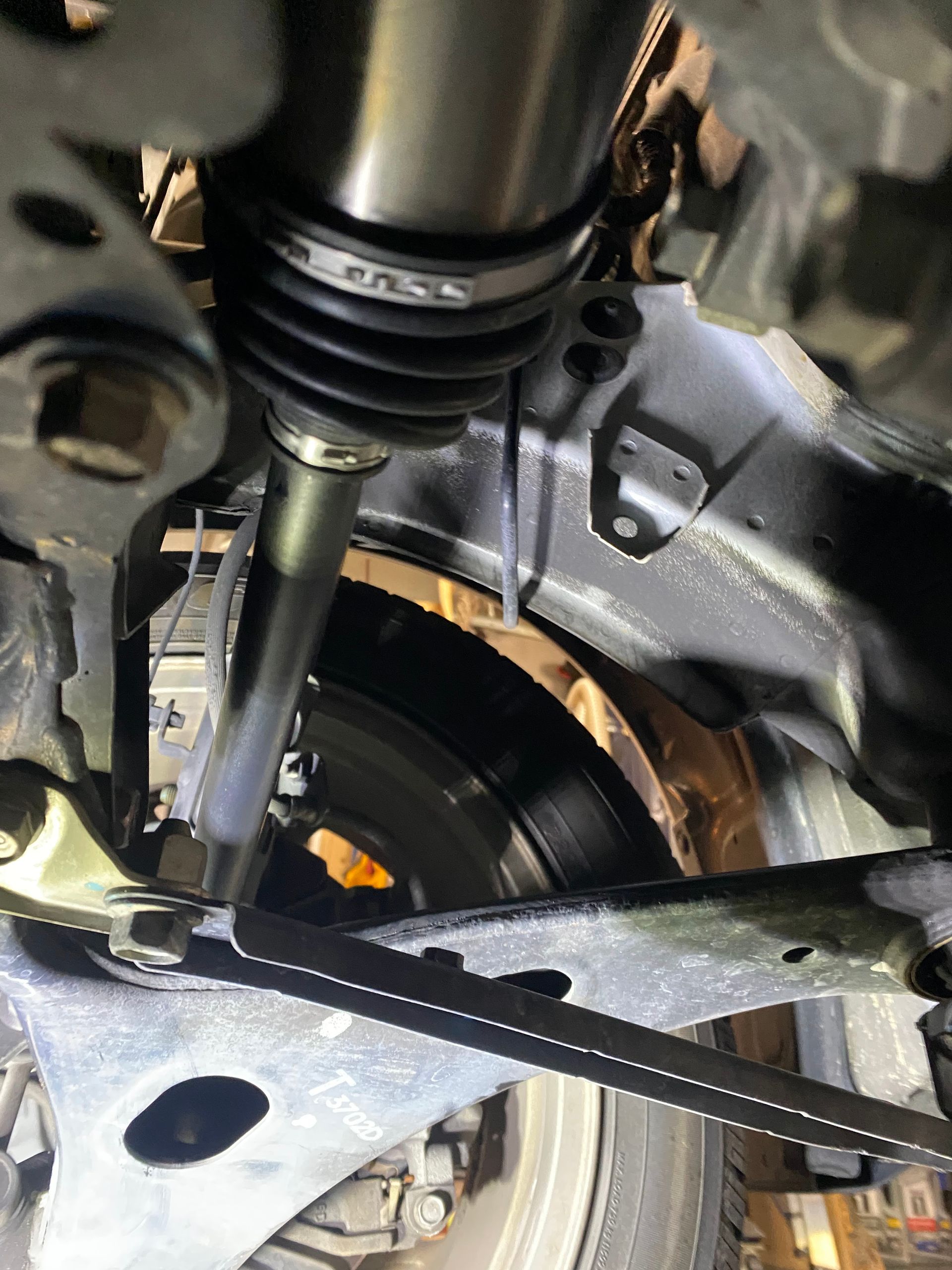 A close up of the underside of a car with a brake disc.