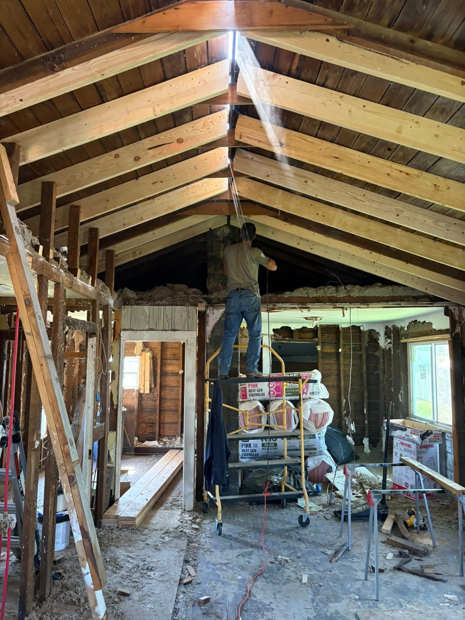 Person on scaffold working on ceiling during renovation.
