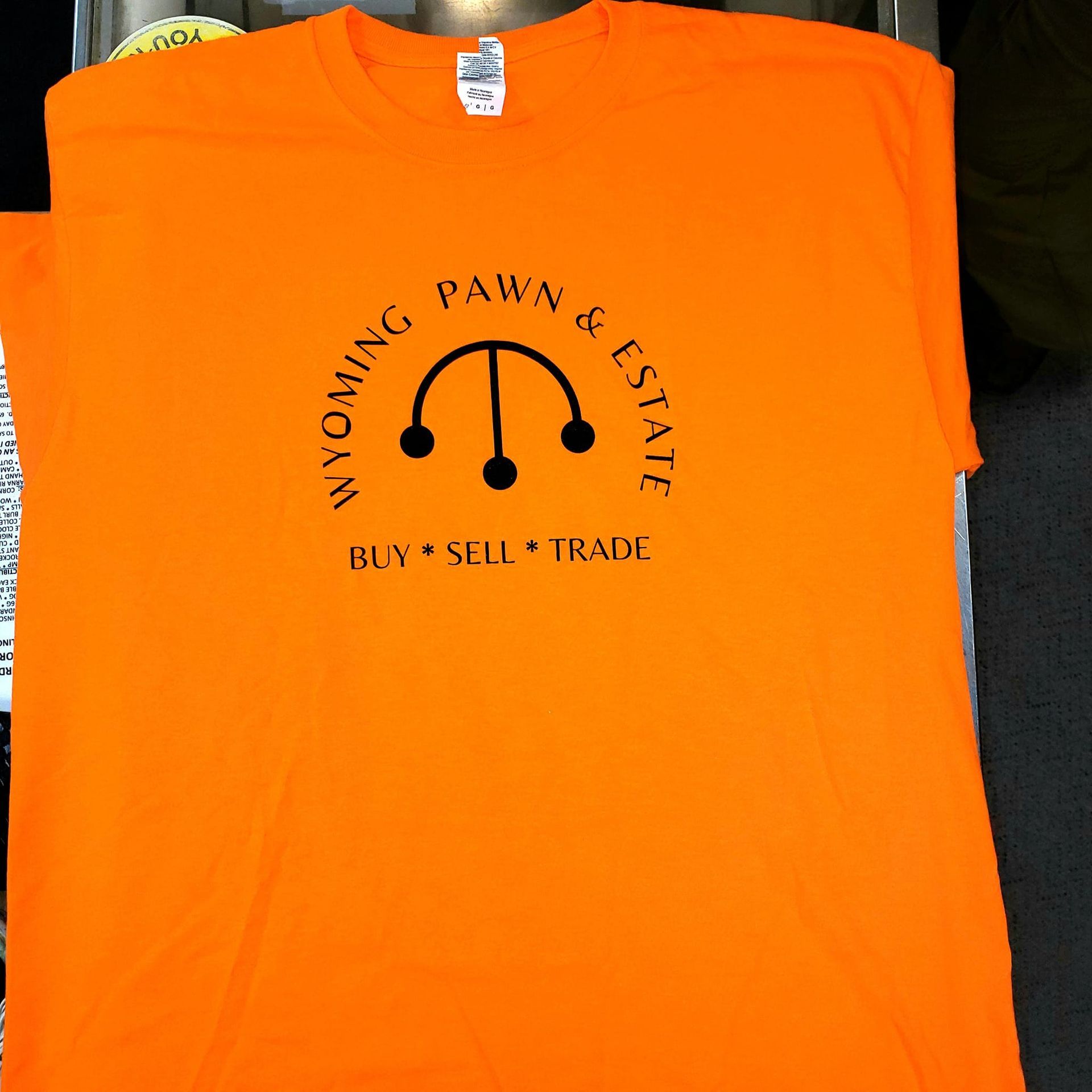 An orange shirt that says wyoming pawn & estate