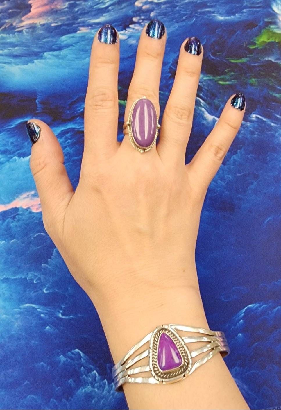 A woman wearing a purple ring and a purple bracelet