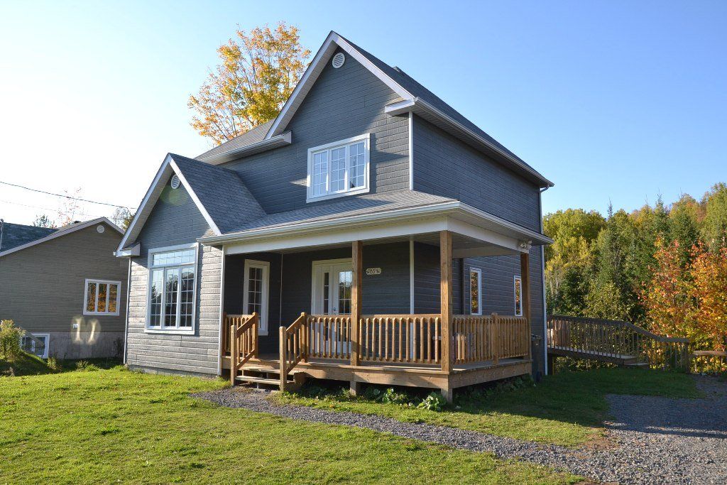 Une maison avec un porche et une clôture devant