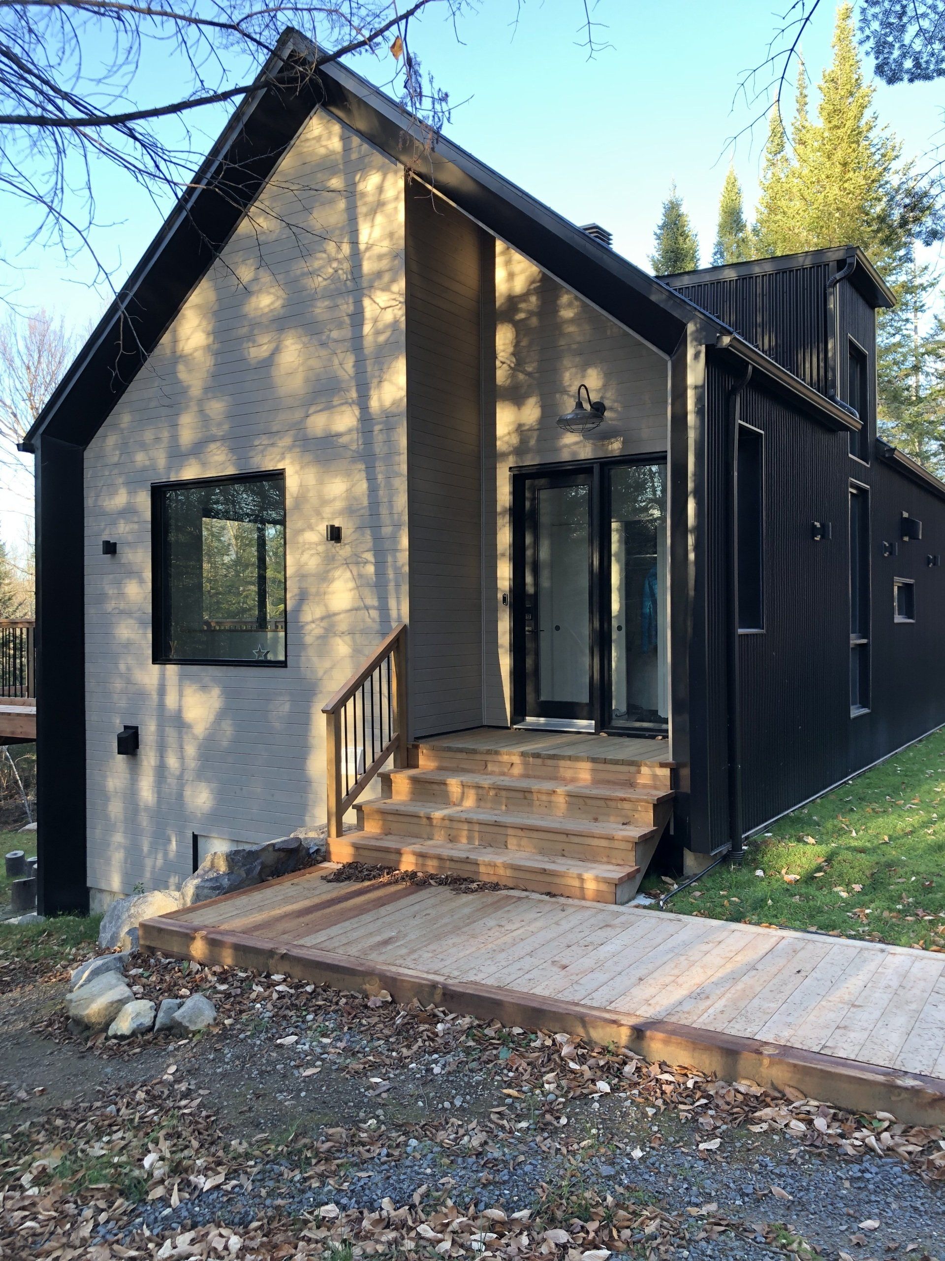 Une petite maison avec des escaliers menant à la porte d'entrée.
