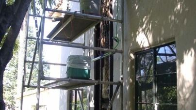 A scaffolding is sitting on the side of a building next to a window.