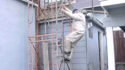 A man is climbing a fire escape outside of a building.