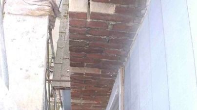 A close up of a brick wall on a building with smoke coming out of it.