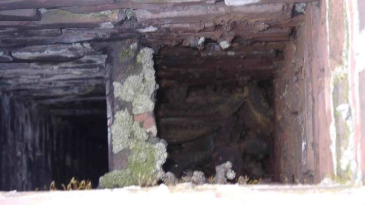 There is a hole in the wall that looks like a tunnel.