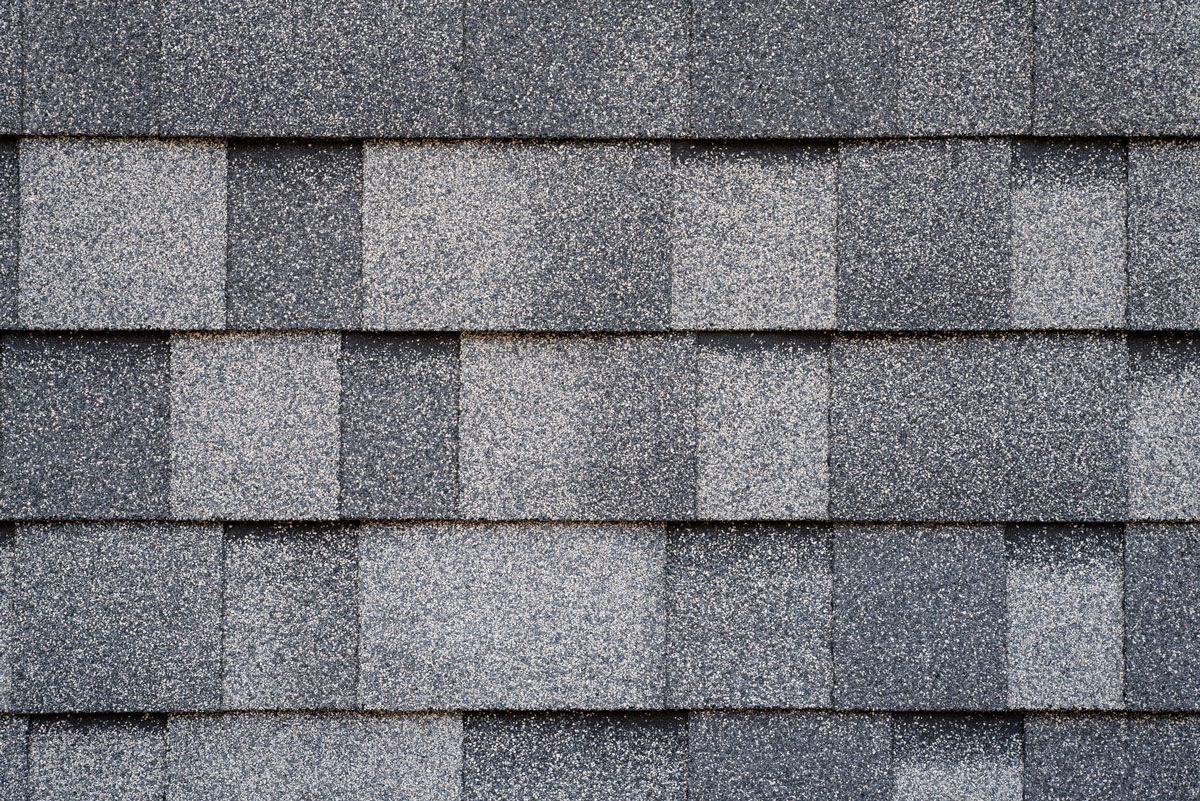 Dark gray asphalt roof shingles in a staggered pattern.