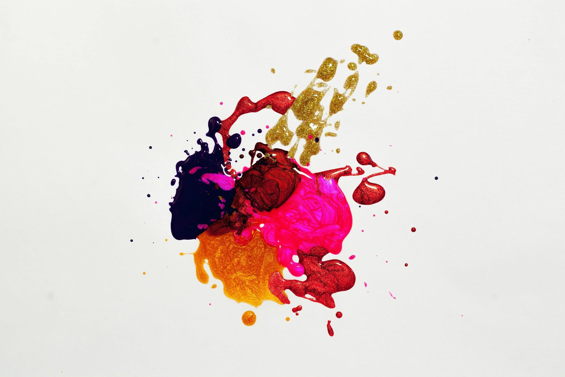 A mixed splatter of paints on a blank background.