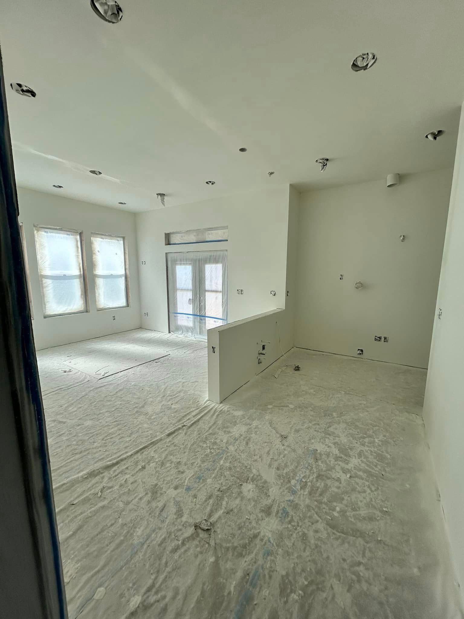 A large empty room with a lot of white paint on the floor and walls.