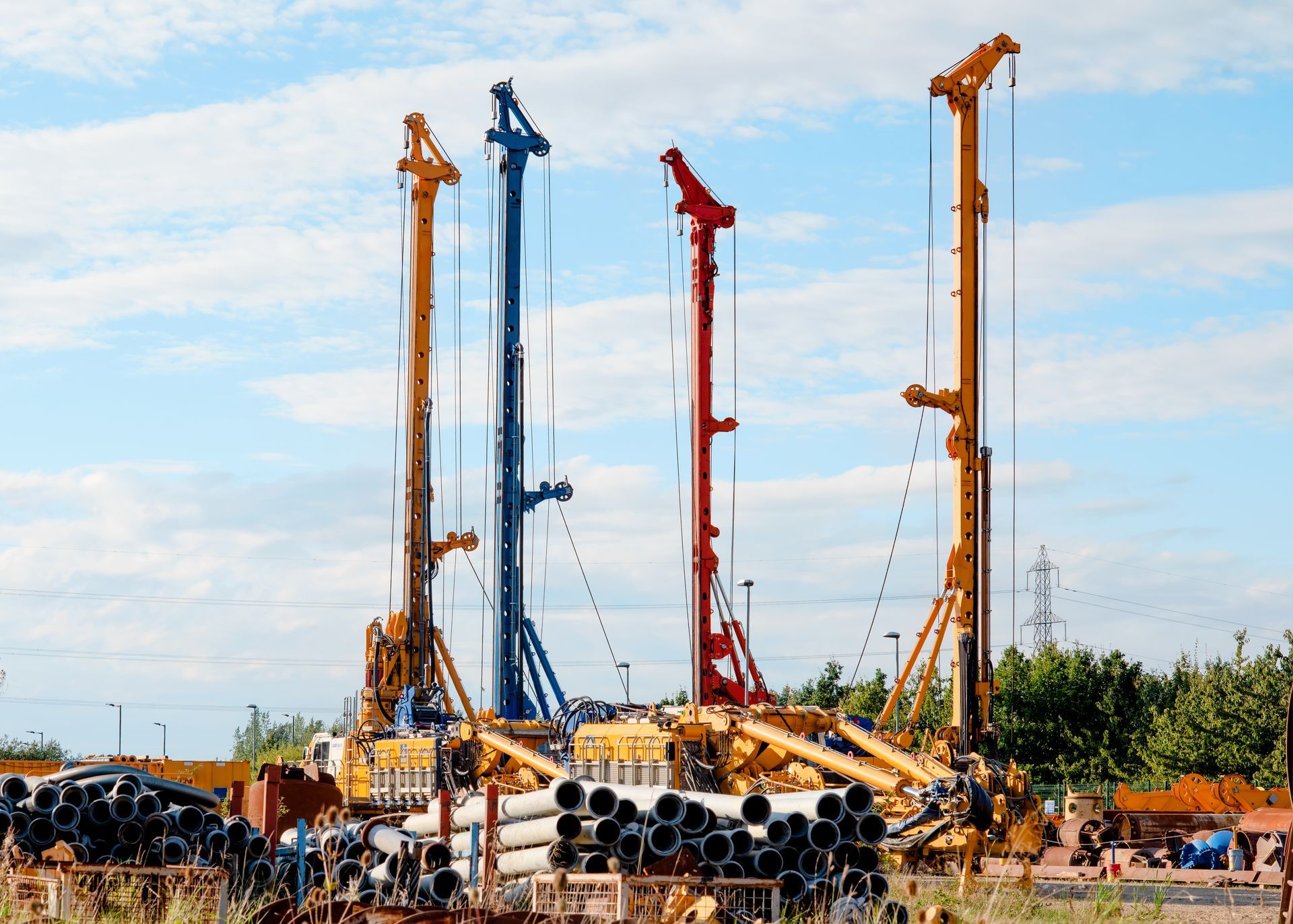 View of multiple piling rig machines in a storage yard, after service and repair