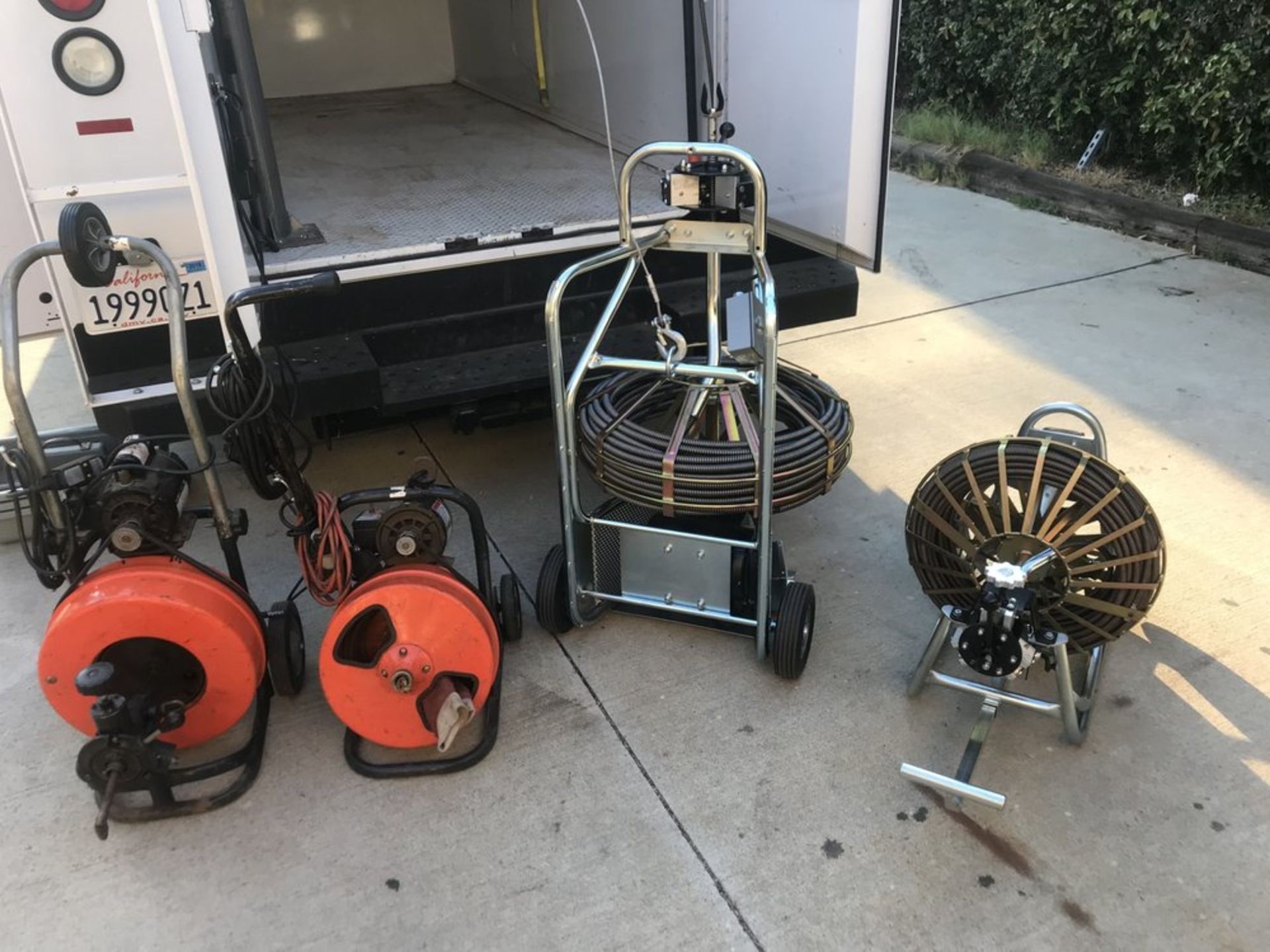 A bunch of drain cleaners are sitting on the ground in front of a truck.