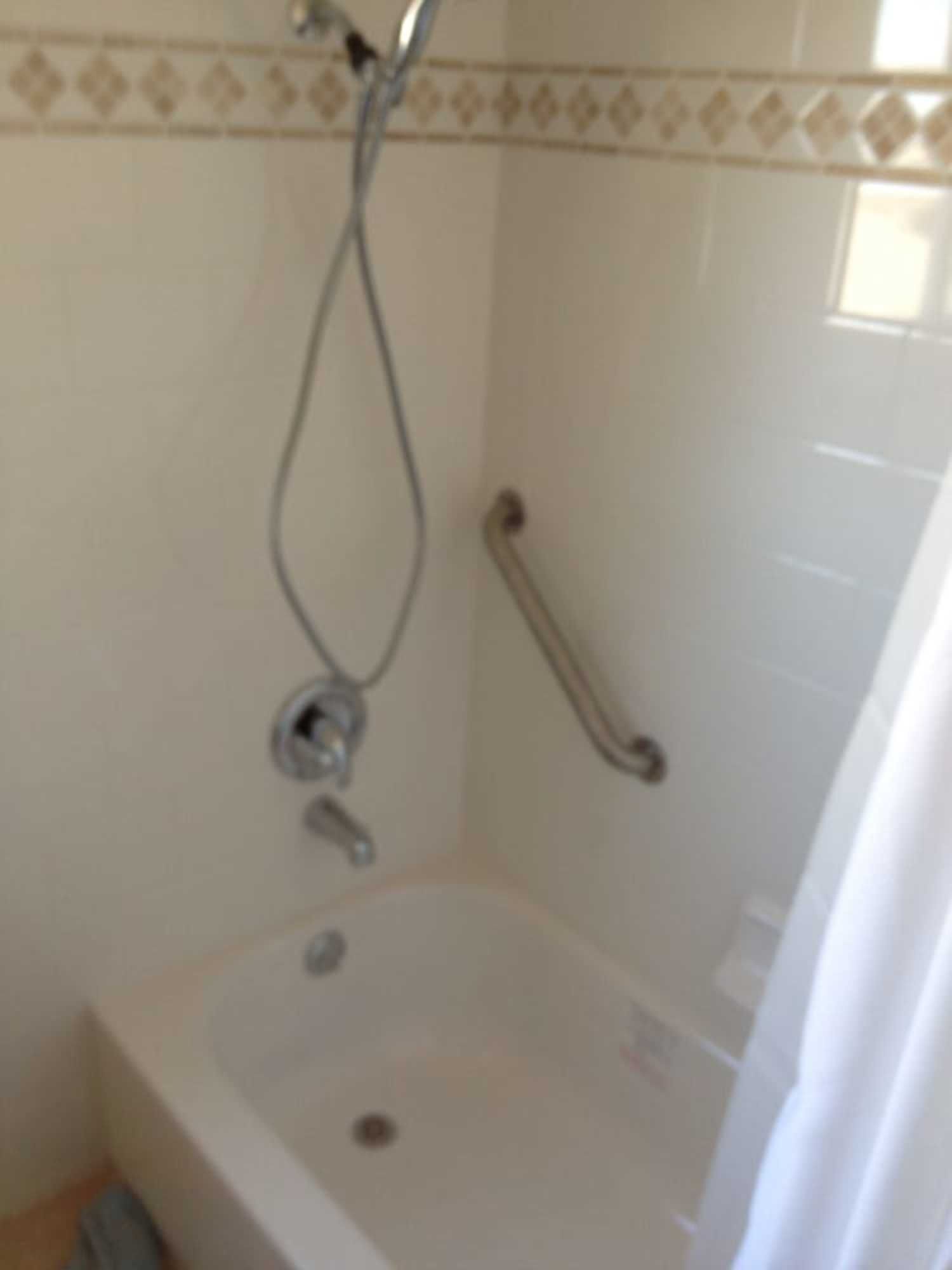 A bathroom with a bathtub and a shower head