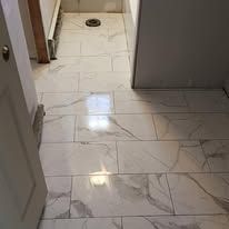 A bathroom with marble tile floors and a toilet.