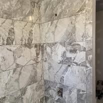 A bathroom with a lot of tiles on the wall.