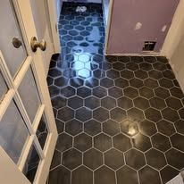 A bathroom with a black hexagon tile floor.