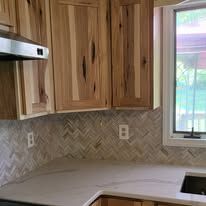 A kitchen with wooden cabinets , a sink , and a window.