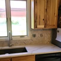 A kitchen with a sink , dishwasher , and window.