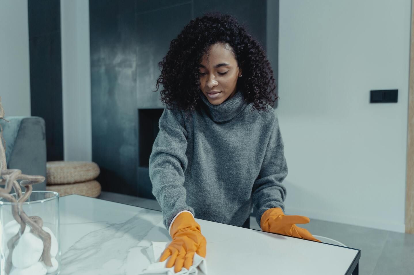 A professional house cleaner wiping the table