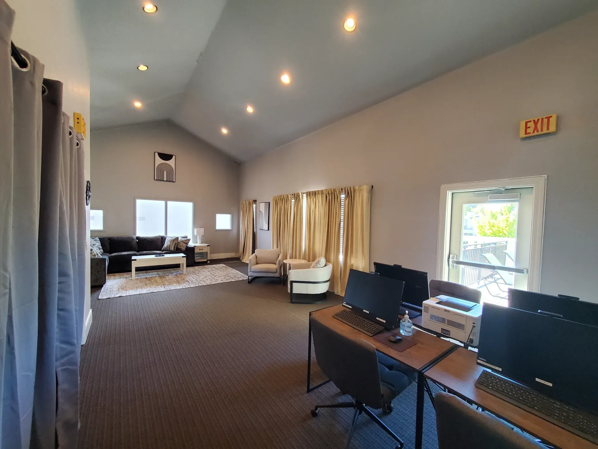 Spacious community lounge with seating and computer desks.