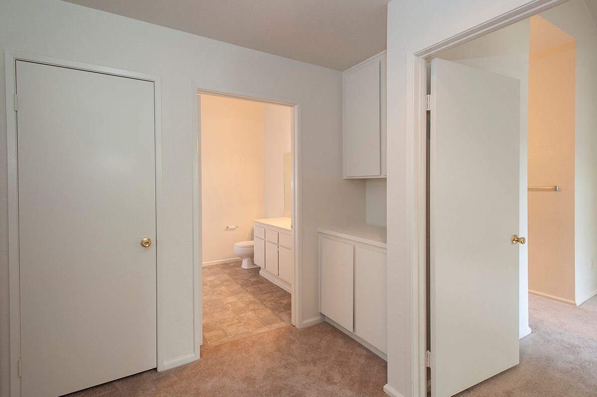 Interior view of an apartment showing a bathroom with vanity, sink, and toilet.